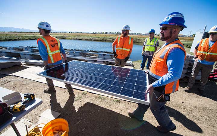 research-areas-53270 Volunteers assemble and install a floating PV array.
